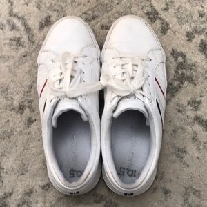 Nautica white sneakers with red & blue stripes on the outer side of each shoe.